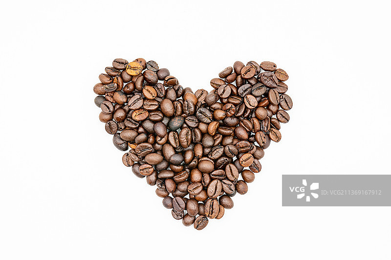 白色背景上分离的咖啡豆，咖啡豆组成的心形特写图片素材