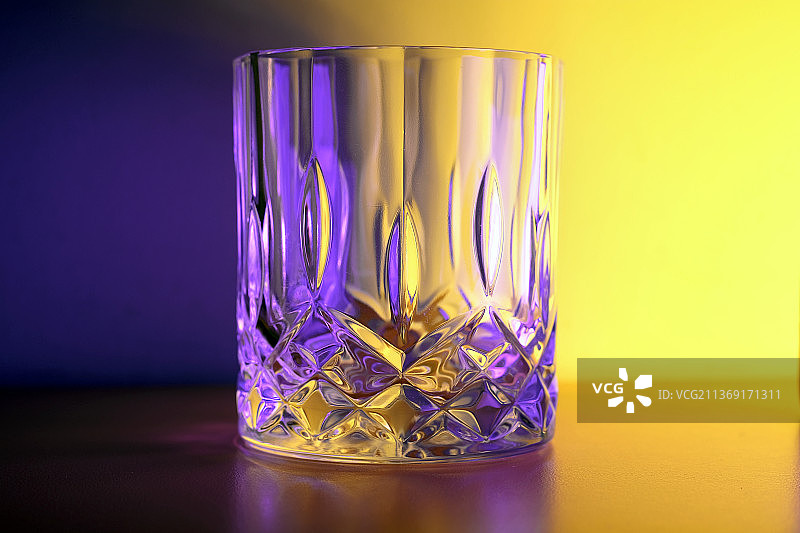 威士忌酒杯，彩色背景下桌子上的酒杯特写图片素材