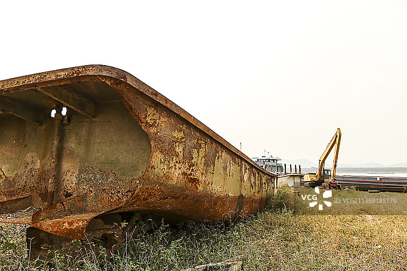 草地上长满铁锈的铁船局部特写图片素材
