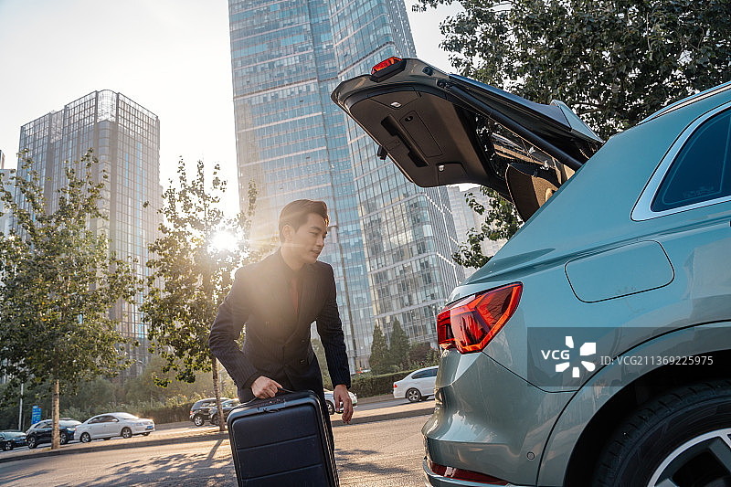 商务人士拿着行李箱在CBD图片素材