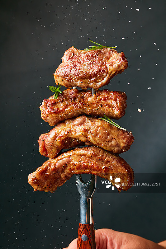 黑色背景的烤牛脊柳图片素材