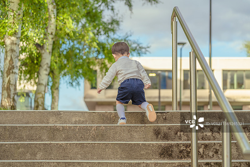 大学校园里走上台阶的小男孩图片素材