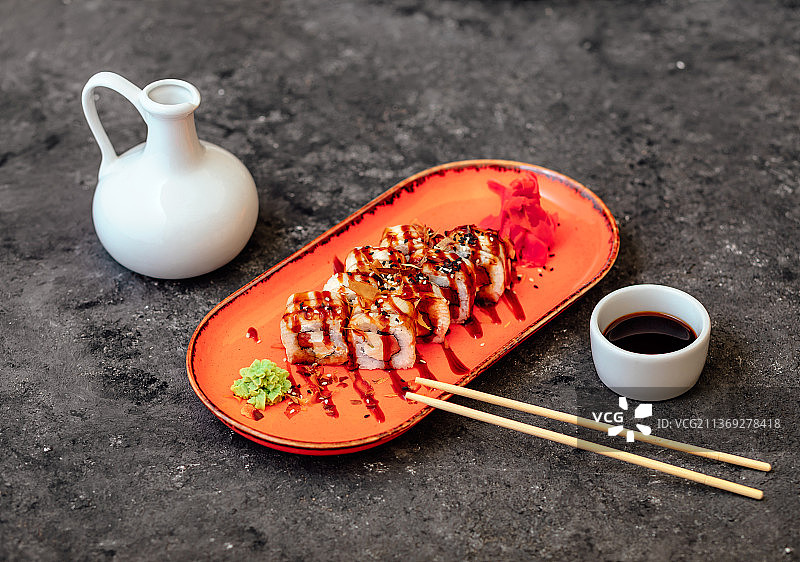 红色盘子上的寿司卷和筷子图片素材