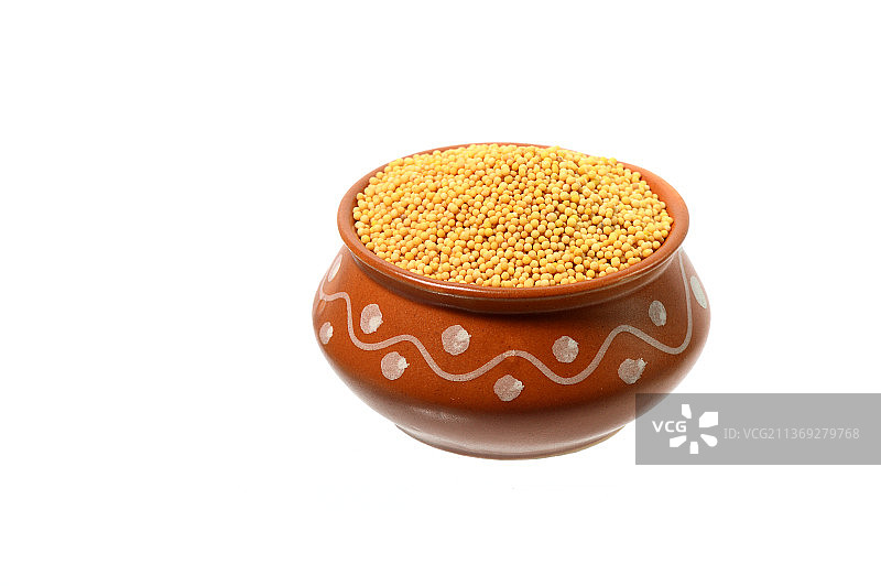 白色背景上孤立的粘土罐中的黄色芥菜籽图片素材