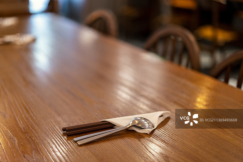 餐厅里的木制餐桌上的餐具图片素材
