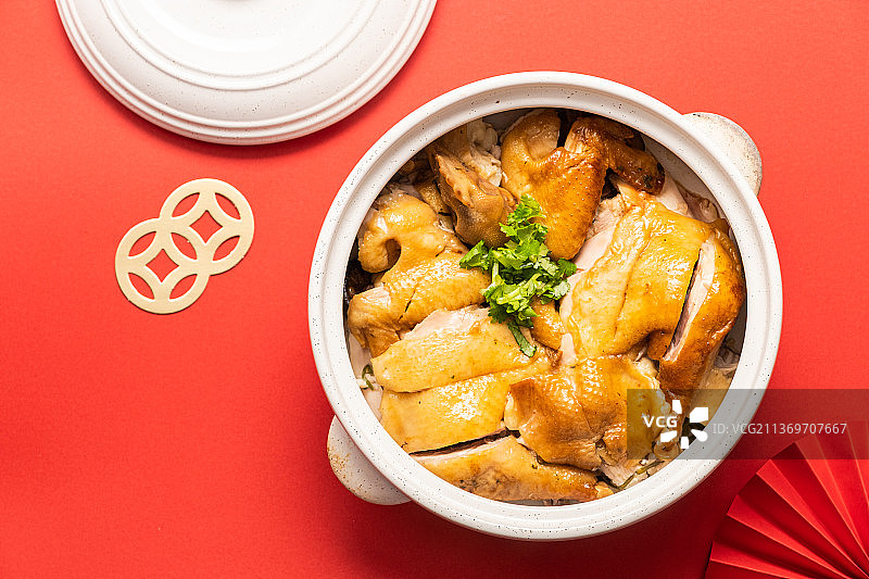 红色背景下砂锅中清炖鸡的高角度视图图片素材