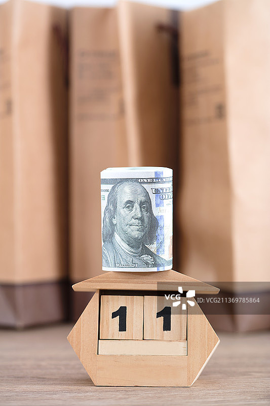 购物袋前显示11日的台历和美元钞票图片素材