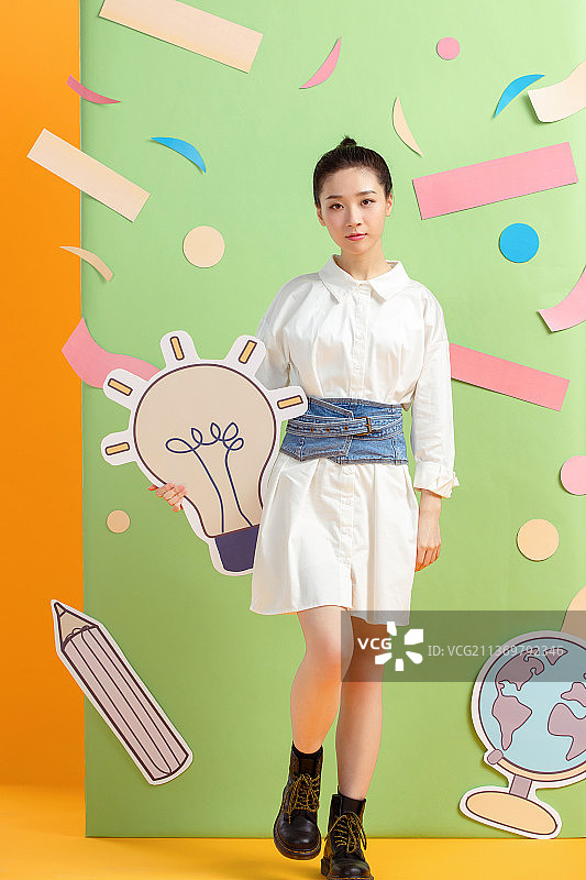 拿着灯泡图标的年轻女孩图片素材