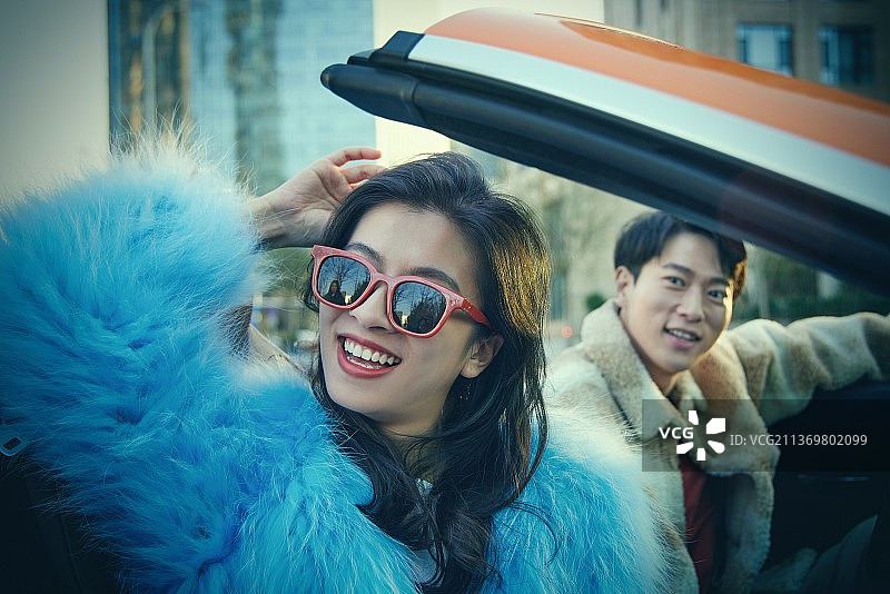 快乐的青年情侣驾驶跑车出行图片素材