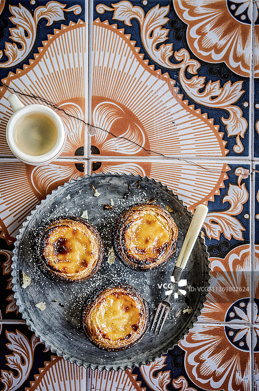 葡萄牙瓷砖上的葡式蛋挞和咖啡图片素材