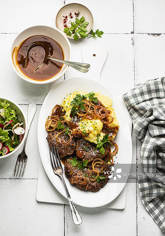 自制肉末炸肉排配肉泥、炸洋葱和配菜沙拉图片素材