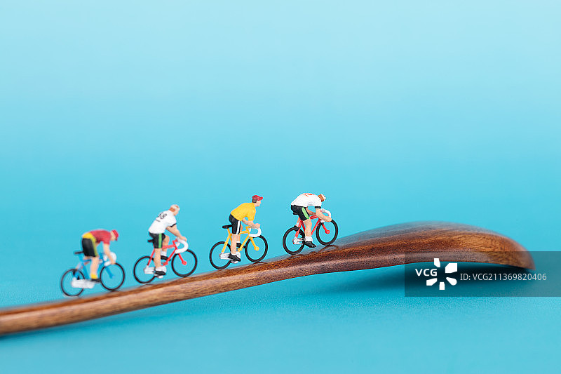 一队骑行的旅行者微缩模型在木质勺子上图片素材