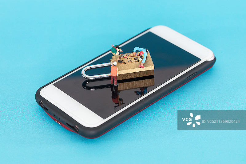 微缩摄影人偶试图打开手机上的密码锁图片素材