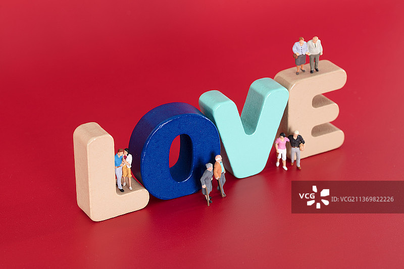 立体英文单词LOVE和上面各种各样年龄段的情侣人偶模型图片素材