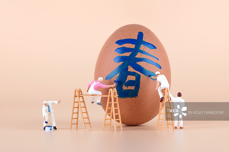 粉刷匠在鸡蛋上粉刷一个春字图片素材