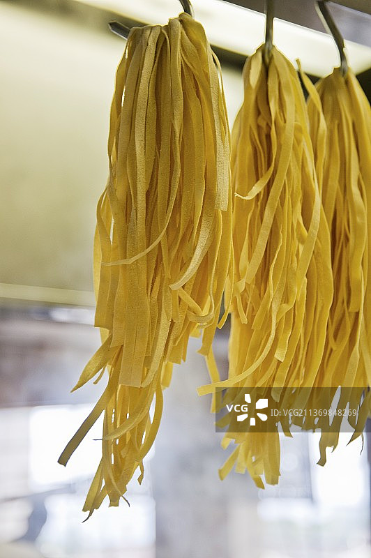 挂在挂钩上晾干的意大利宽面条图片素材