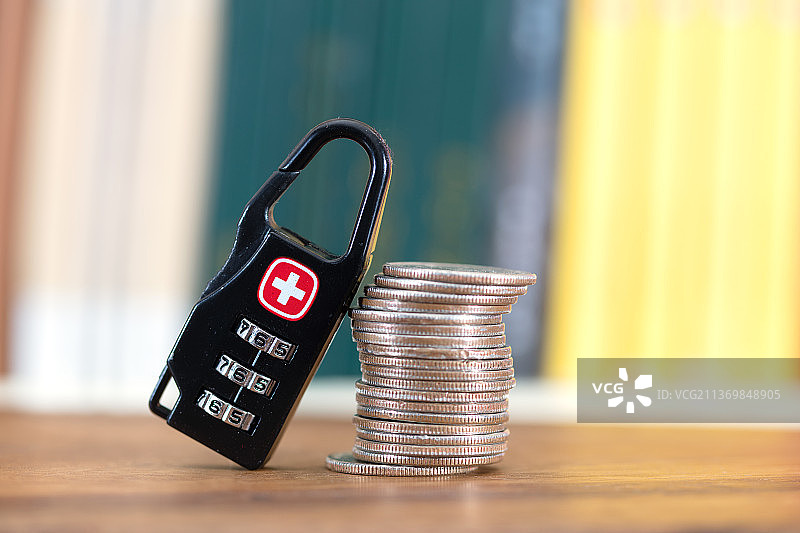 硬币和密码锁在书籍前图片素材