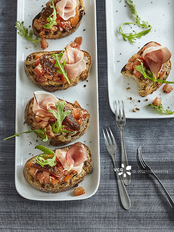 配帕尔马火腿、番茄和芝麻菜的意式烤面包图片素材