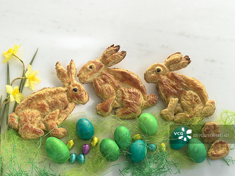 酥皮复活节兔子，装饰着彩色复活节彩蛋、巧克力蛋、水仙花图片素材