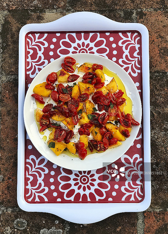 托盘上放着烤桃子和晒干的西红柿图片素材