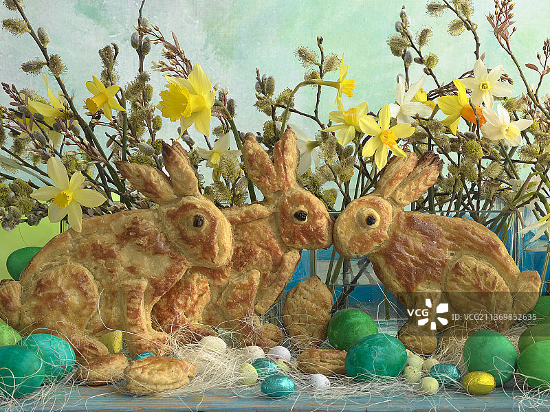 千层酥皮复活节兔子、彩色复活节彩蛋、巧克力蛋、黄水仙和柳树猫图片素材