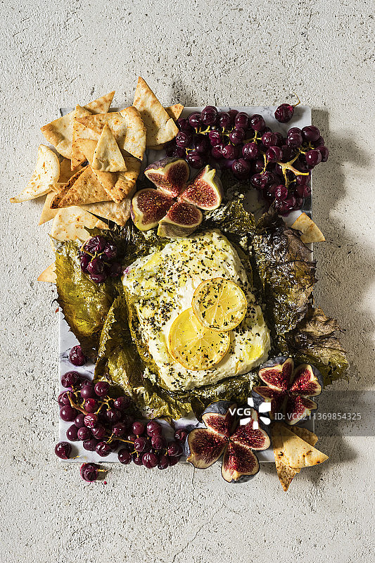 葡萄叶烤羊奶酪配烤葡萄、皮塔薯片和无花果图片素材