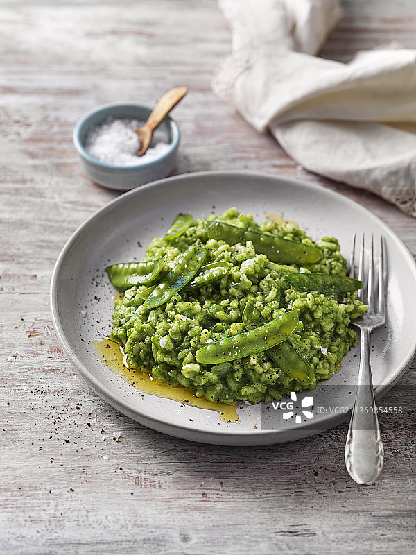 青豆和甜豆制成的绿色意大利烩饭图片素材