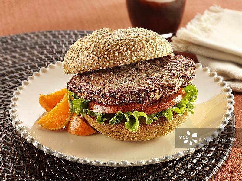 配有番茄和生菜的土耳其肉饼汉堡，搭配橘子片图片素材