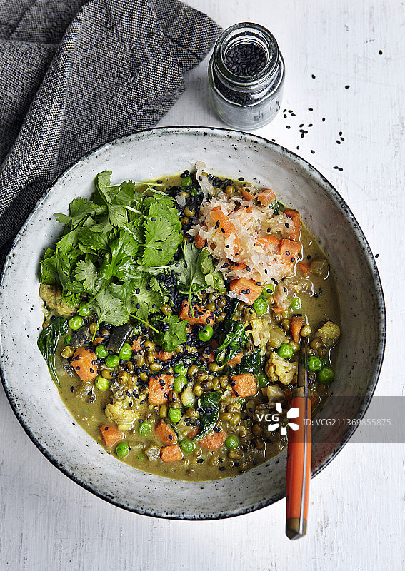 纯素蔬菜炖菜配胡萝卜、香菜、青豆、菠菜、小扁豆和黑芝麻图片素材