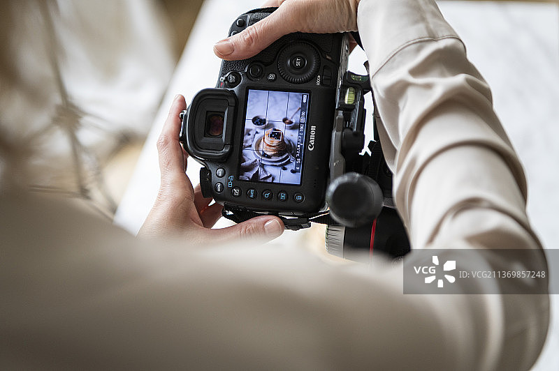 女人在数码相机上看煎饼的照片图片素材