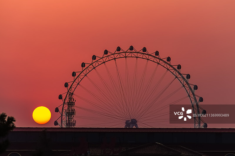 中国山东省日照市，著名旅游景点，国家森林公园，橙色的夕阳下的摩天轮图片素材