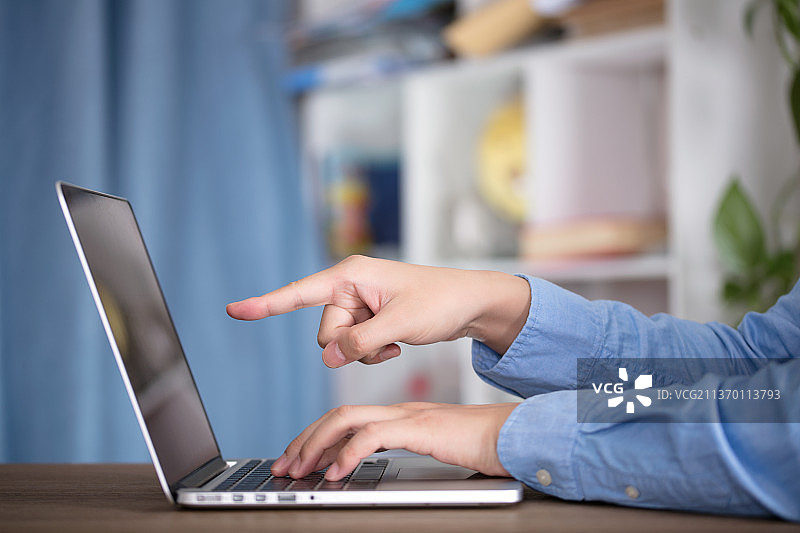 男士使用笔记本电脑工作在室内图片素材