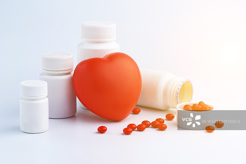 红心和药瓶药片放在白色背景上图片素材