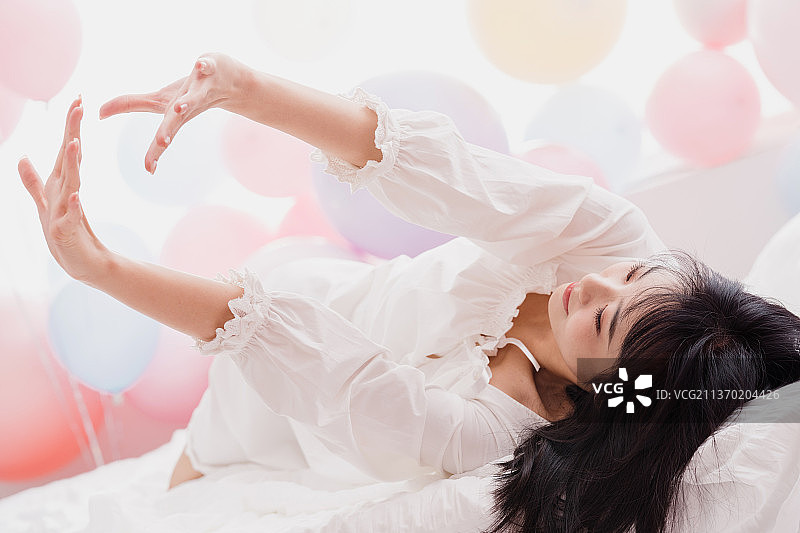 年轻女人躺在床上伸懒腰图片素材