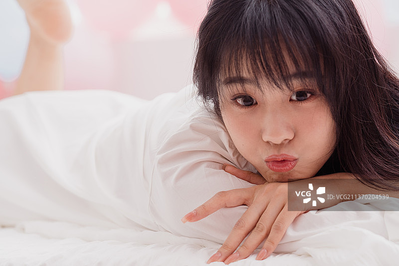 年轻女人在床上躺着图片素材