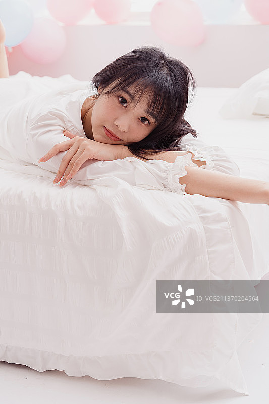 年轻女人在床上躺着图片素材