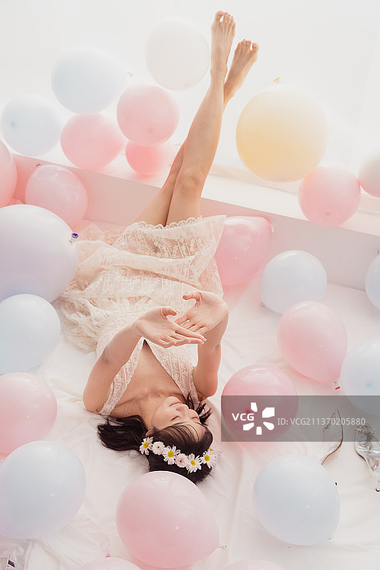 穿着婚纱的女孩躺在床上脚悬空图片素材