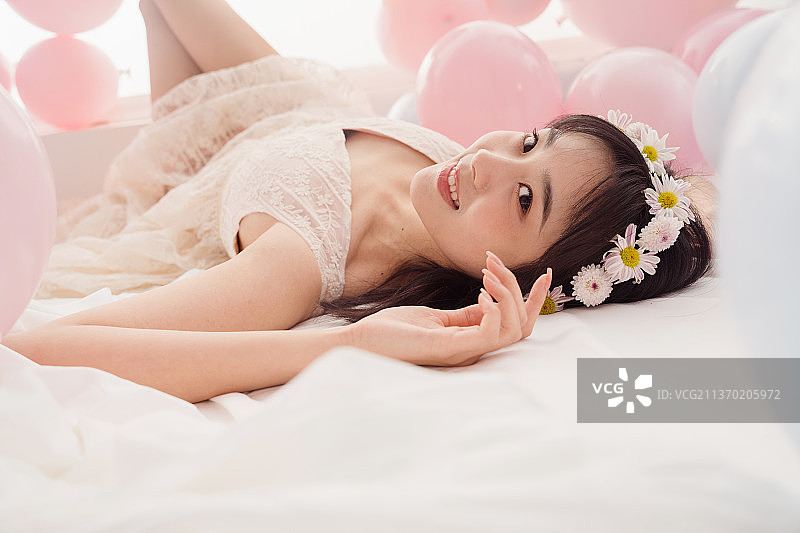 穿着婚纱的女孩躺在注视镜头图片素材