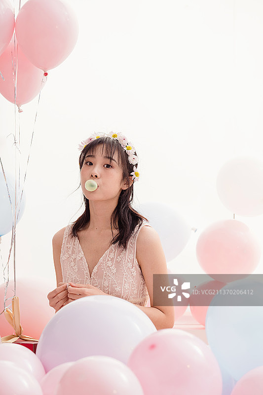 穿着婚纱的女孩在床上吹泡泡糖图片素材