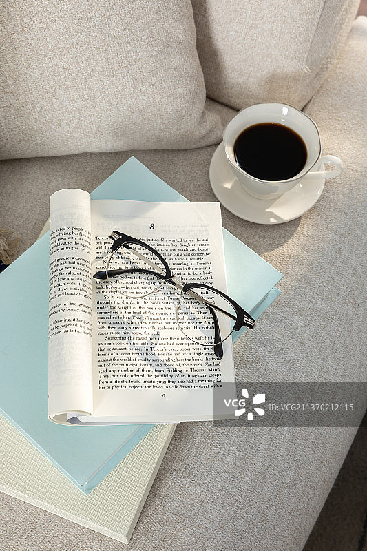 放松舒适的物品和背景与沙发、靠垫、书、眼镜图片素材