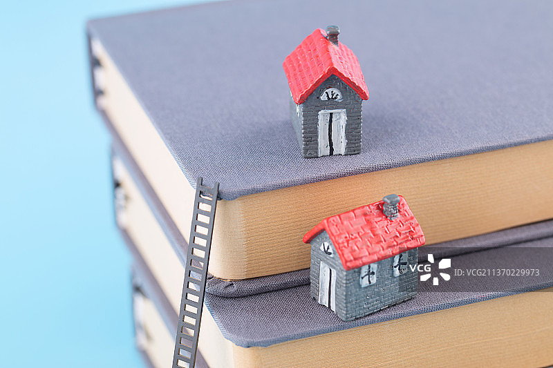 高高在书上的小房子模型和攀登的云梯图片素材