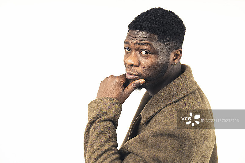 双手放在下巴上的黑人男子，白色背景图片素材