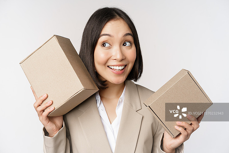 猜测盒子里物品的亚洲女销售员图片素材