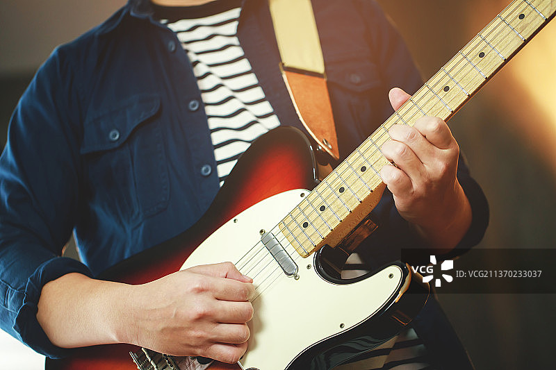 男子弹吉他的腰部特写图片素材