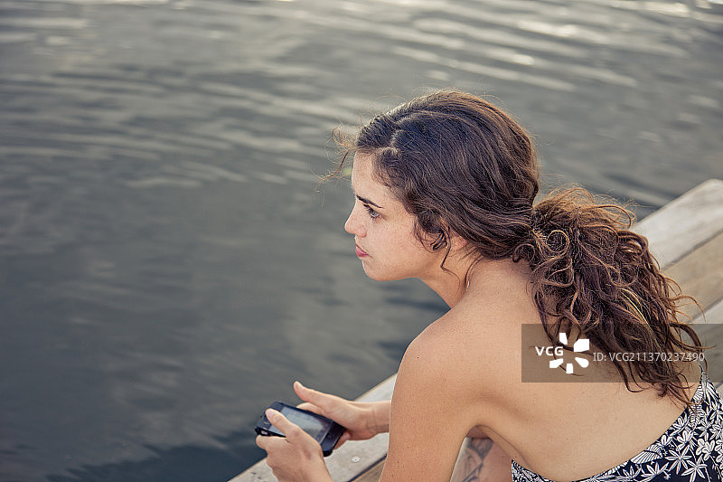 在科罗拉多湖边发短信的年轻黑发女子图片素材