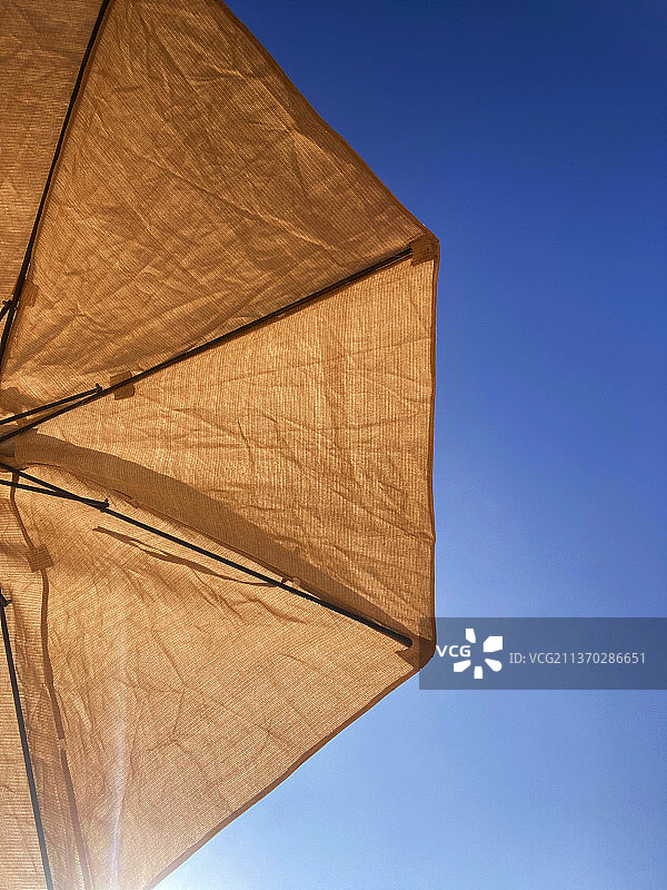 蓝色晴空下的黄色阳伞仰视图图片素材