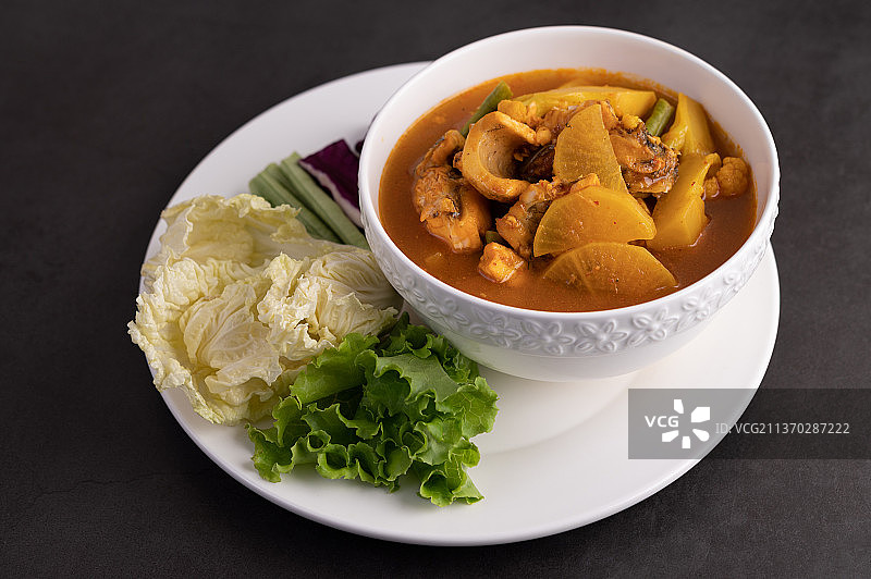 搭配蛇头鱼的黄色咖喱，泰国菜，桌上碗中食物的特写图片素材