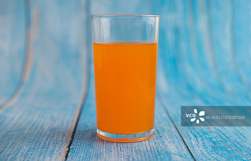 蓝色木地板上的橙汁图片素材