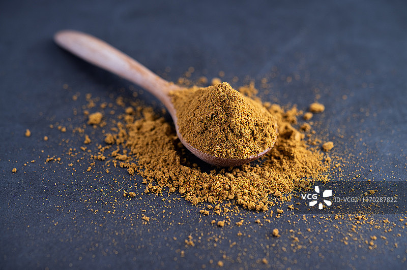 勺子里的香料放在水泥地上图片素材