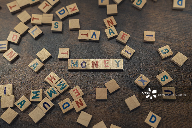 由分散的木制字母组成的“金钱”字样概念图图片素材